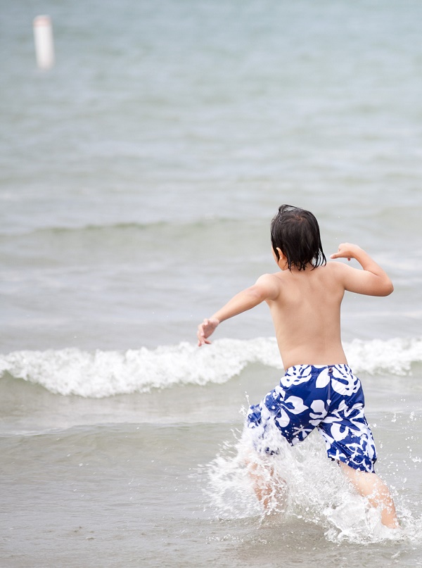 Boy running into water