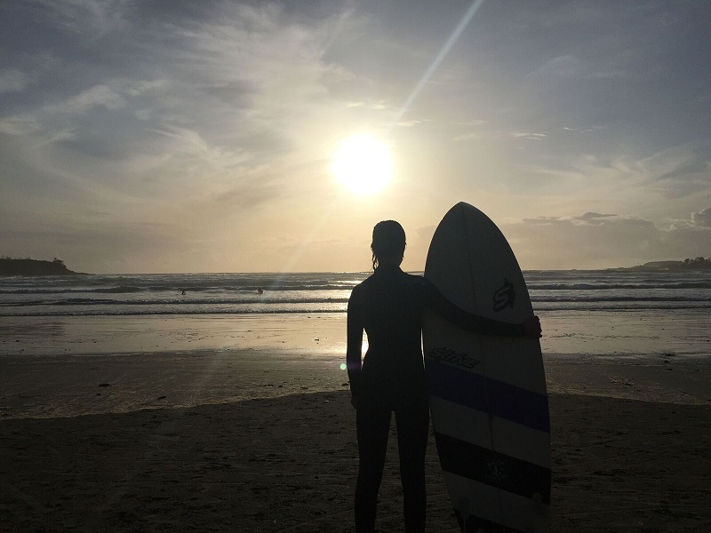 Surfer with surf board in sunset