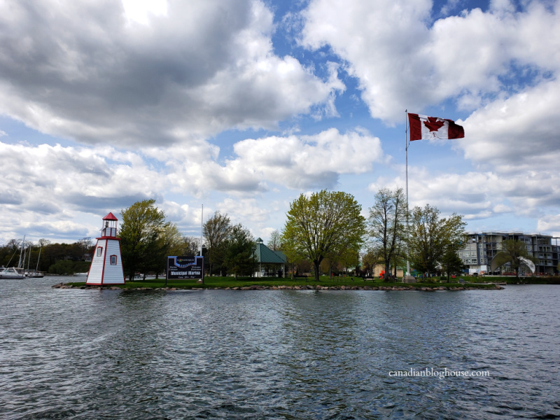 View of lighthouse and Canadian flag leaving Gananoque harbour by boat